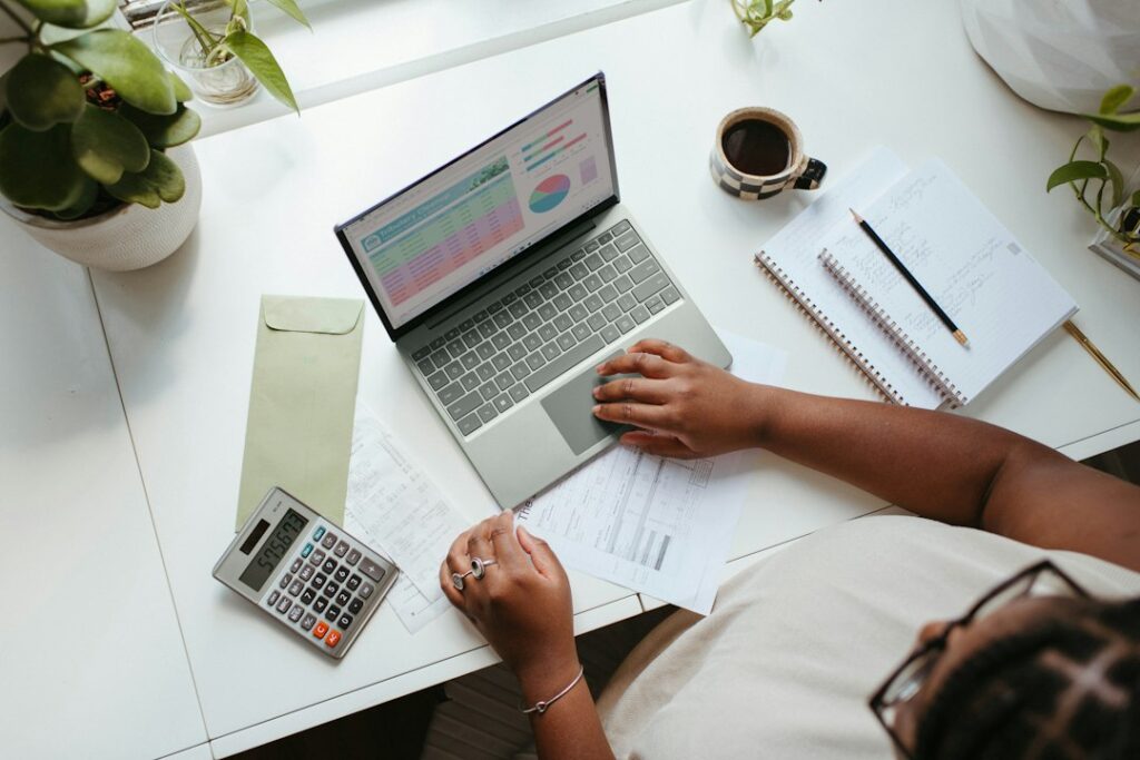 Small-business owner working on a laptop and financial forecast